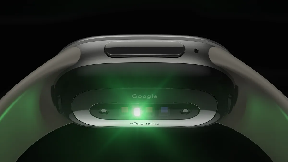 Parte de baixo de um Fitbit Edge, com o sensor de frequência cardíaca aceso em verde e as marcações Google e Fitbit Edge